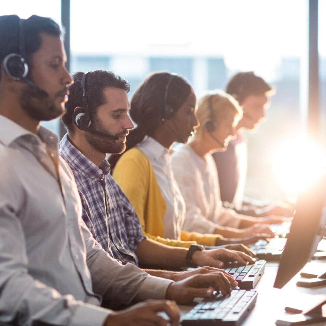 Team of colleagues working at their desk with headset in the office